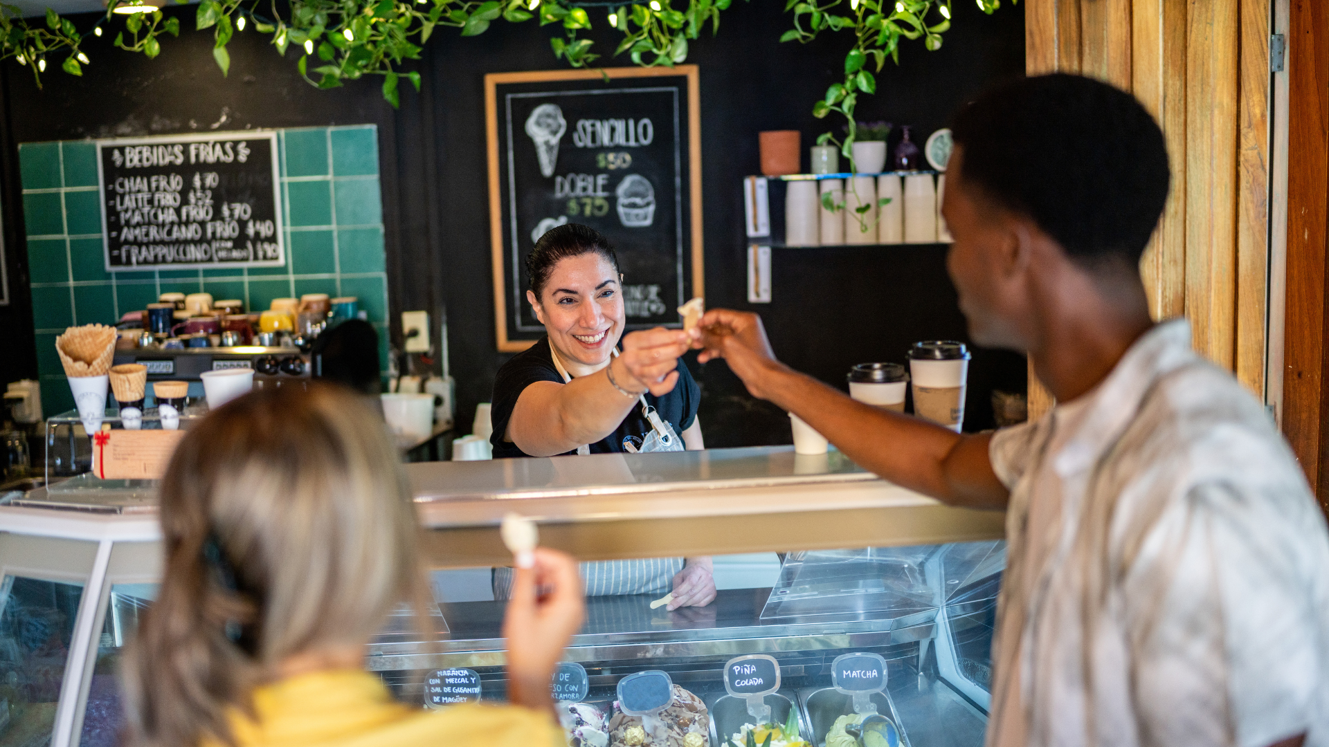 A gelato shop employee serving a customer, showcasing efficient service and a welcoming atmosphere. Highlights how self-service kiosks in restaurants can streamline operations and enhance customer satisfaction.